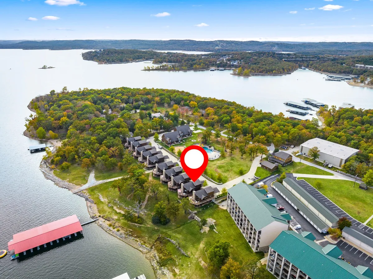 Overlooking the lake, this image shows resort buildings nestled among colorful trees and a marina, with serene water inviting outdoor activities. The wide open spaces and lakeside setting evoke the sense of adventure and freedom described for pet-friendly stays.